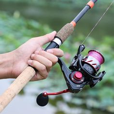 a person holding a fishing rod with a reel attached to it and spinning the rods