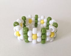 a close up of a bracelet made out of plastic beads and green and white beads