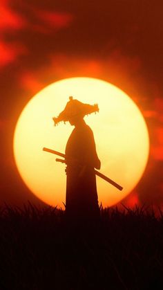 the sun is setting behind a silhouette of a person holding two large wooden sticks in their hands