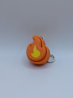 an orange keychain with a yellow flame on it