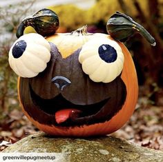 a pumpkin decorated with googly eyes and horns