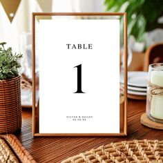 a table number is displayed in front of a candle and wicker basket on the table