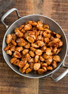 a bowl filled with nuts sitting on top of a wooden table