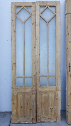 two wooden doors sitting side by side next to each other in front of a white wall