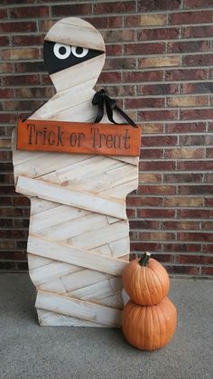 a trick or treat sign next to a pumpkin