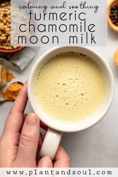 a person holding a cup of coffee in their hand with the words, calming and soothing turmic chamomile moon milk