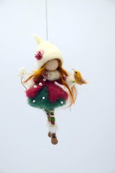 a doll hanging from a string with a bird on it