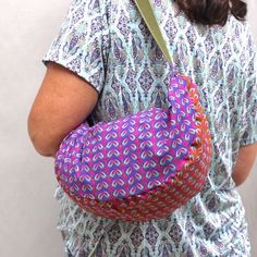 a woman carrying a pink and purple bag