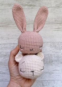 a hand holding a small crocheted stuffed animal with its eyes closed and ears wide open