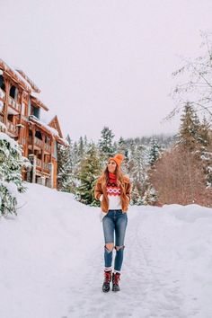 a woman standing in the middle of a snow covered road