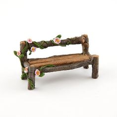 a small bench made out of wood with flowers on the back and branches around it