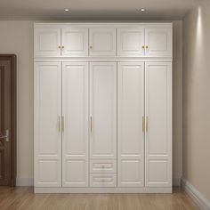 an empty room with white cupboards and wood flooring in the center, along with a door leading to another room