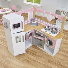 a toy kitchen with pink and white appliances