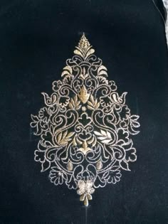 a black jacket with gold embroidered design on it