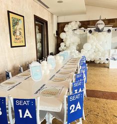 a long table set up with blue and white chairs for an airplane themed birthday party