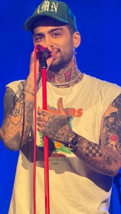 a man with tattoos on his arm holding a microphone