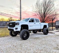 a white truck parked on top of a gravel road