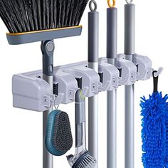 a broom, brush and other cleaning supplies hanging on a rack