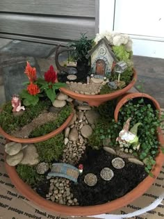 a potted planter filled with lots of plants and small gnome figurines