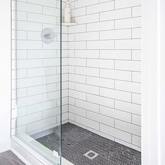 a white tiled bathroom with a walk in shower