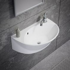 a white sink sitting on top of a bathroom counter next to a wall mounted mirror