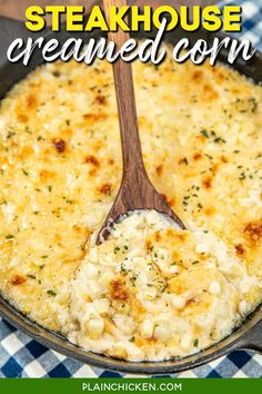 a skillet filled with cheese covered corn and topped with a wooden spoon in it