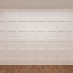 an empty room with wood flooring and white paneled walls in the corner is shown