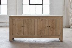 a large wooden cabinet in an empty room