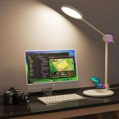 a desktop computer sitting on top of a desk next to a camera and a cell phone