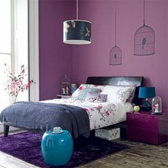 a bedroom with purple walls and white furniture