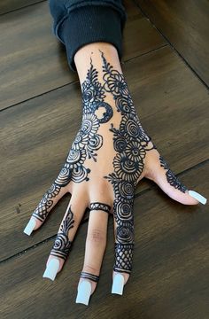 a woman's hand with henna tattoos on it