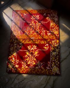 two red and yellow cloths sitting on top of a marble floor next to a window