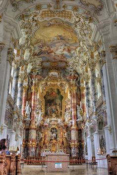 the interior of a large church with gold and white paint on it's walls