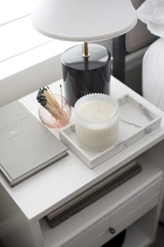 a candle and some books on a white table