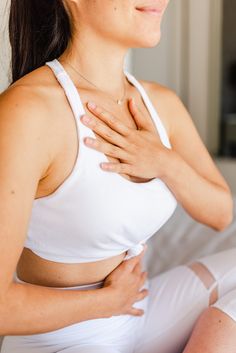 a woman in white shirt holding her chest