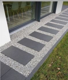 an image of a walkway made out of stones and gravel in front of a window