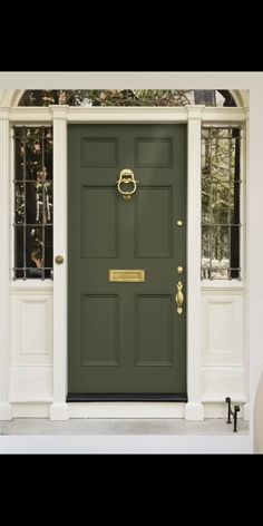 the front door is painted green and has gold hardware on it, along with several different colors