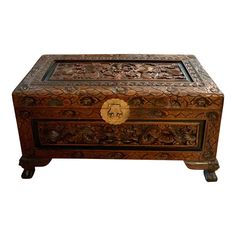 an ornate wooden box with carvings on the top and bottom, sitting on wheels in front of a white background