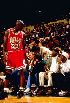 a basketball player standing on the court in front of an audience at a sporting event