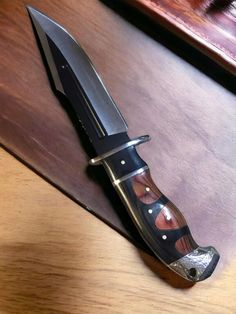 a large knife sitting on top of a wooden table