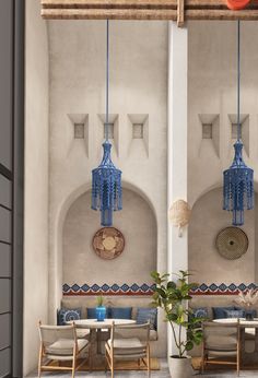 an outdoor seating area with blue lanterns hanging from the ceiling and wicker chairs on the floor