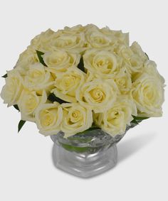 a bouquet of white roses in a glass vase