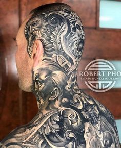 the back of a man's head with tattoos on his neck and chest,