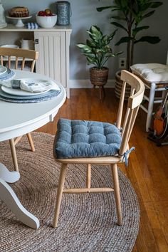 slate blue chair pads on natural wooden chairs with painted white dining table in farmhouse dining room Undining Room, Painted Pedestal Table, Dining Chair Ideas, Cushions For Dining Chairs, Dining Chair Pads, Dining Room Accents, Painted Buffet, Kitchen Chair Cushions, Gray Dining Chairs