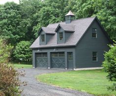 a large gray house surrounded by trees and grass