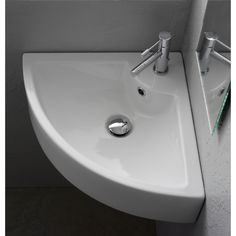 a white sink in a bathroom next to a wall mounted toilet paper dispenser