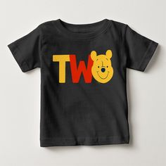 a black t - shirt with winnie the pooh on it's chest and two letters