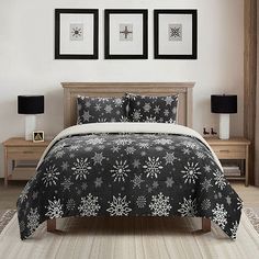 a bed with snowflakes on it and two framed pictures above the headboard