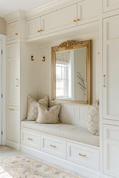 a bench with pillows and a mirror on the wall in front of white closets