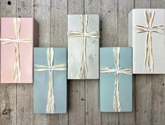 four wrapped gift boxes with bows on them sitting on a wooden table next to each other